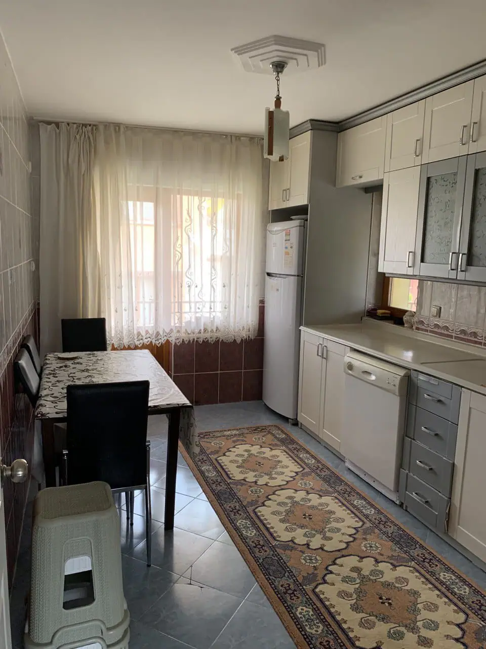 Yemek masası, buzdolabı ve bulaşık makinesiyle tam donanımlı mutfak