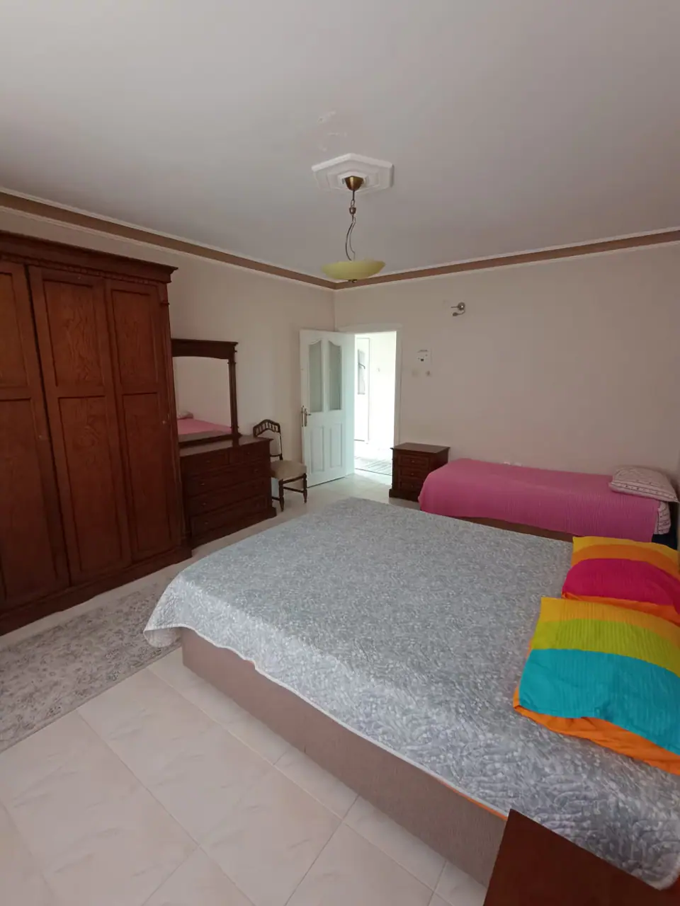 Çift ve tek kişilik yataklı aile odasında ahşap gardırop ve şifonyer